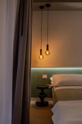 a room with two beds and a table and two lights at Holivù Apartments in Palermo
