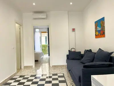 a living room with a blue couch and a checkered floor at Palermo central stay in Palermo