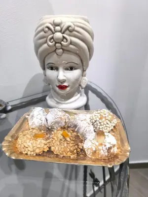a statue of a woman holding a tray of donuts at Dimora Filangeri in Santa Flavia