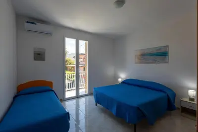 a bedroom with two beds and a balcony at I Piani Apartment in Trabia