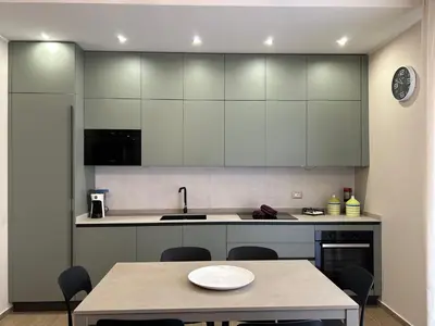 a kitchen with white cabinets and a table with chairs at Notarbartolo Casa Centrale in Palermo