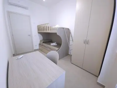 a small room with a bunk bed and a table at Al Centro di Palermo - Casa Bertolino in Palermo