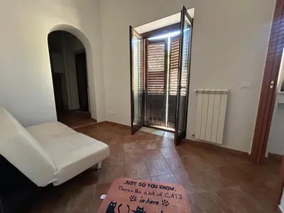 a living room with a white couch and a glass door at La Casa di Cat in Palermo
