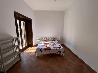 a bedroom with a bed in the corner of a room at La Casa di Cat in Palermo