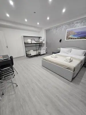a bedroom with a large bed and a desk at La Mantia Luxury Rooms in Palermo