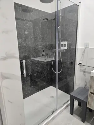 a shower with a glass door and a sink at La Mantia Luxury Rooms in Palermo