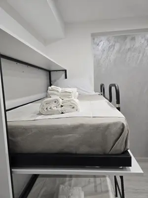 a bed with white sheets on it in a room at La Mantia Luxury Rooms in Palermo