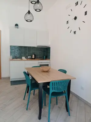 a kitchen with a wooden table and chairs and a clock at Blu di Sicilia in Palermo
