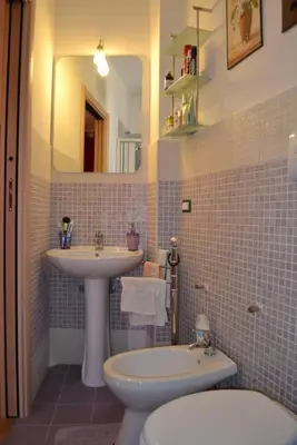 a bathroom with a sink and a toilet and a mirror at Casa Colorata in Palermo