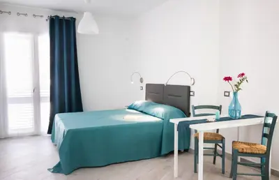 a bedroom with a bed and a table and chairs at Stanze del Mare in Balestrate