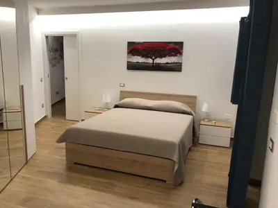a bedroom with a bed and a red tree at La Maison de Claude in Palermo