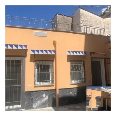 a orange building with windows and a balcony at La Maison de Claude in Palermo