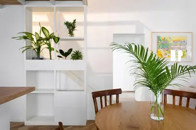 a dining room table with a vase with plants on it at Palazzo Castrone, Luxury Apartment in Palermo