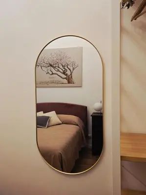 a mirror in a room with a bed and a tree at DorMimmo a Palermo, nel cuore pulsante della città! in Palermo