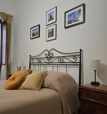 a bed in a bedroom with pictures on the wall at DorMimmo a Palermo, nel cuore pulsante della città! in Palermo