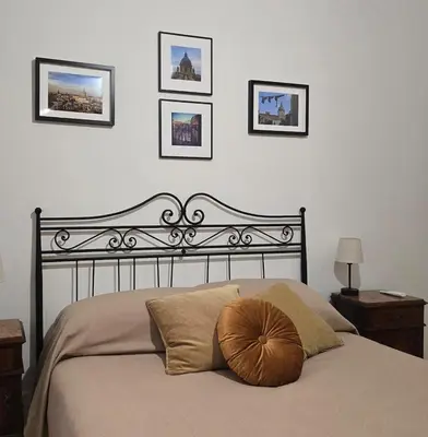a bed with a brown pillow on it in a bedroom at DorMimmo a Palermo, nel cuore pulsante della città! in Palermo