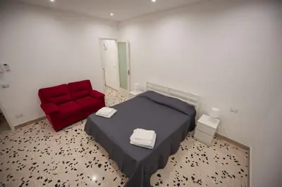 a bedroom with a red bed and a red chair at Holiday House Annunziata 2 in Termini Imerese