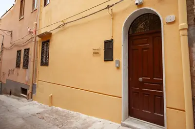 an alley with a brown door on a building at Holiday House Annunziata 2 in Termini Imerese