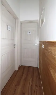 a hallway with two white doors and a wooden floor at Cupola Verde Rooms in Palermo
