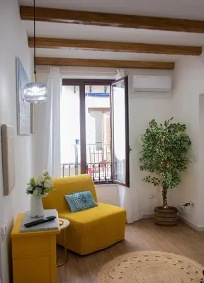 a living room with a yellow couch and a window at Home Simo al Capo in the old center of Palermo in Palermo
