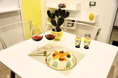 a table with two glasses of wine and a cake at Sikelia House - Comfort Apartment in Palermo