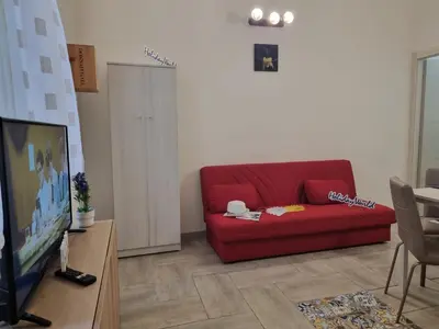 a living room with a red couch and a tv at Casa Vulpi by Holiday World in Palermo