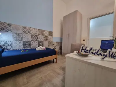 a bedroom with a bed and a desk with a laptop at Casa Vulpi by Holiday World in Palermo
