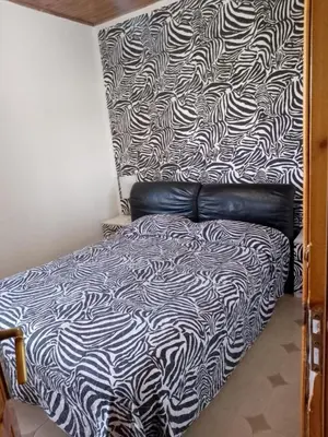 a bedroom with a bed with a black and white blanket at Casa del Sole in Campofelice di Roccella