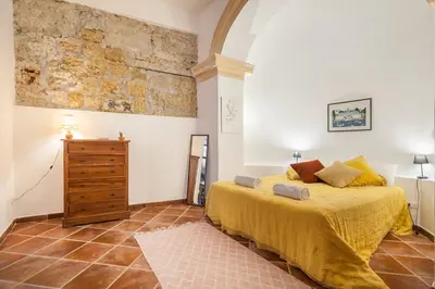 a bedroom with a bed and a dresser in a room at Cortile Galletti - Cool Flat with Private Courtyard in Palermo