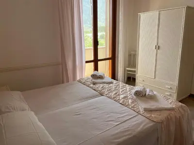 a bedroom with a white bed with towels on it at Villa Glicine a pochi passi dal mare e dal centro in San Vito lo Capo