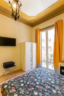 a bedroom with a large bed and a television at Pagano Home Guesthouse in Palermo