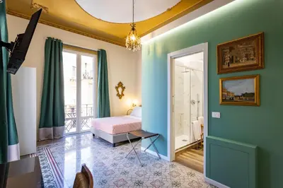 a bedroom with a bed and a door to a balcony at Pagano Home Guesthouse in Palermo