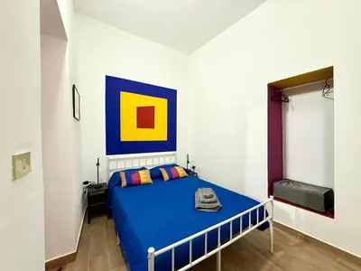 a bedroom with a bed with a blue bedspread at Vicolo Giardi in Palermo