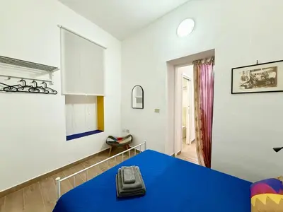 a bedroom with a blue bed in a room at Vicolo Giardi in Palermo