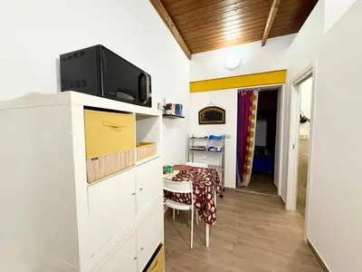 a small kitchen with a table and a microwave at Vicolo Giardi in Palermo