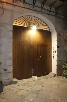 a large wooden door with a light on top at Giacalone15 - EXCLUSIVE APARTMENT IN THE HISTORIC CENTER NEAR THE TEATRO MASSIMO in Palermo