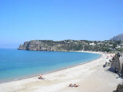 a beach with people laying on the sand and the water at La Casetta nel Porto in Castellammare del Golfo