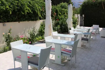 a row of tables and chairs with umbrellas at B&B Selene in San Vito lo Capo