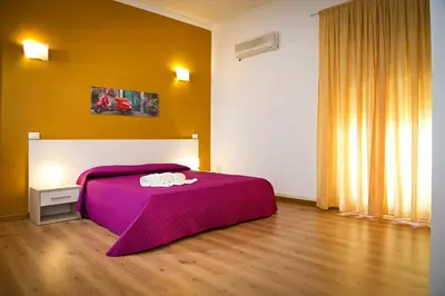 a bedroom with a bed with a purple blanket at Affittacamere le scale in Castellammare del Golfo