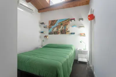 a bedroom with a green bed and a painting on the wall at The Urban Retreat - Relax in the Historic Center in Palermo