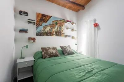 a bedroom with a green bed and a painting on the wall at The Urban Retreat - Relax in the Historic Center in Palermo