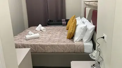a bed with white and yellow pillows on it at Isti e Binisti Flat in Palermo