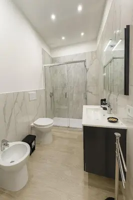 a bathroom with a toilet and a sink and a shower at Kalaciuri Rooms in Palermo