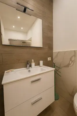 a bathroom with a white sink and a mirror at Kalaciuri Rooms in Palermo
