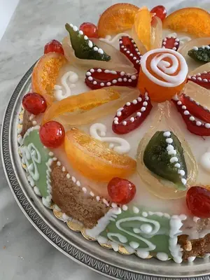 a cake with fruit on it on a plate at Kalaciuri Rooms in Palermo