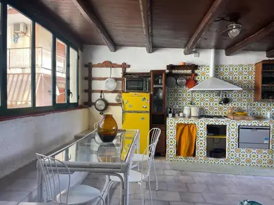 a kitchen with a glass table and a yellow refrigerator at Casa del Sorriso in Isola delle Femmine
