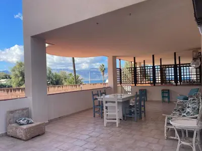 a room with a table and chairs and large windows at Casa del Sorriso in Isola delle Femmine