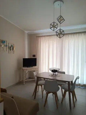 a living room with a table and chairs and a television at Casetta Giardinetto in Altavilla Milicia