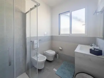 a bathroom with a toilet and a glass shower at Luxury Villa Sicula Trabia in Trabia