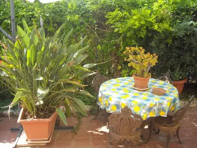 a table and chairs with plants on a patio at Apartment in Villa a Mondello in Mondello